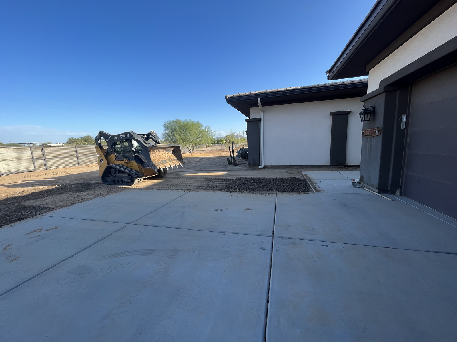 Deere skid steer preparing a residential driveway