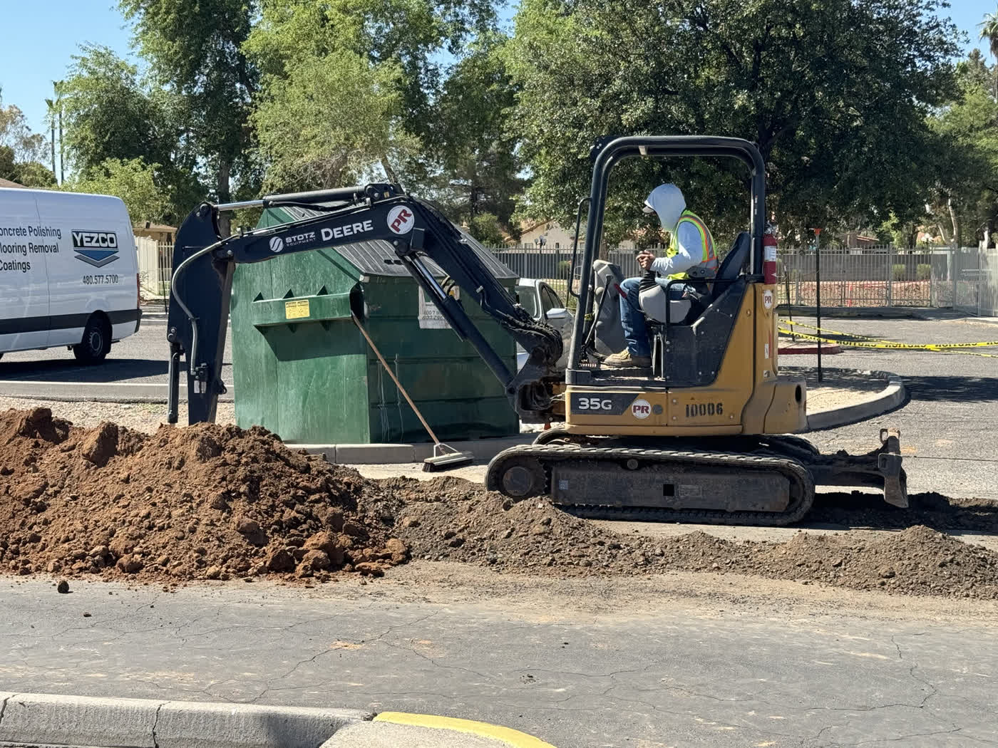 Deere excavator making an asphalt utility cut