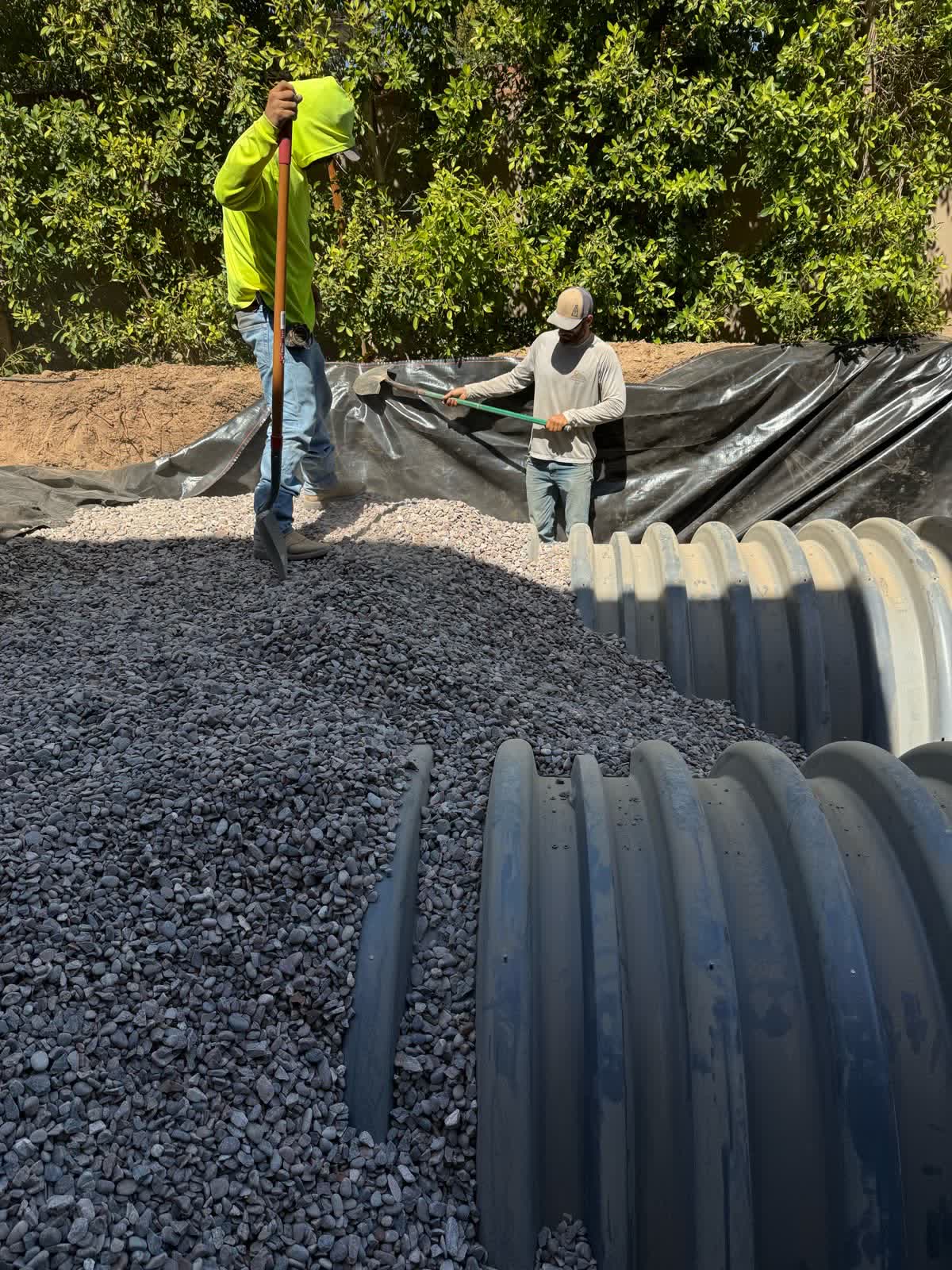 Crew placing gravel around corrugated septic chambers