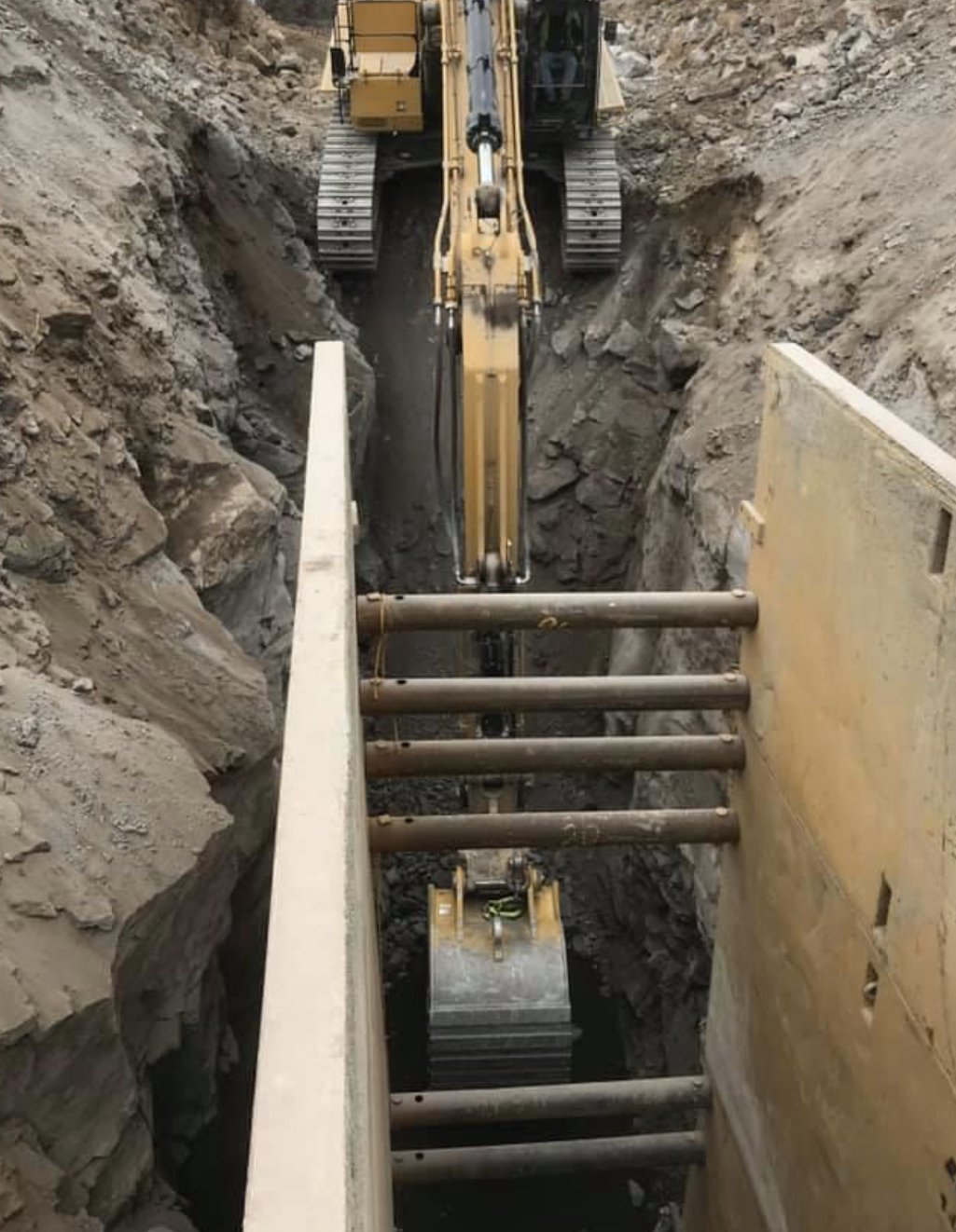 Excavator working in a shored utility trench