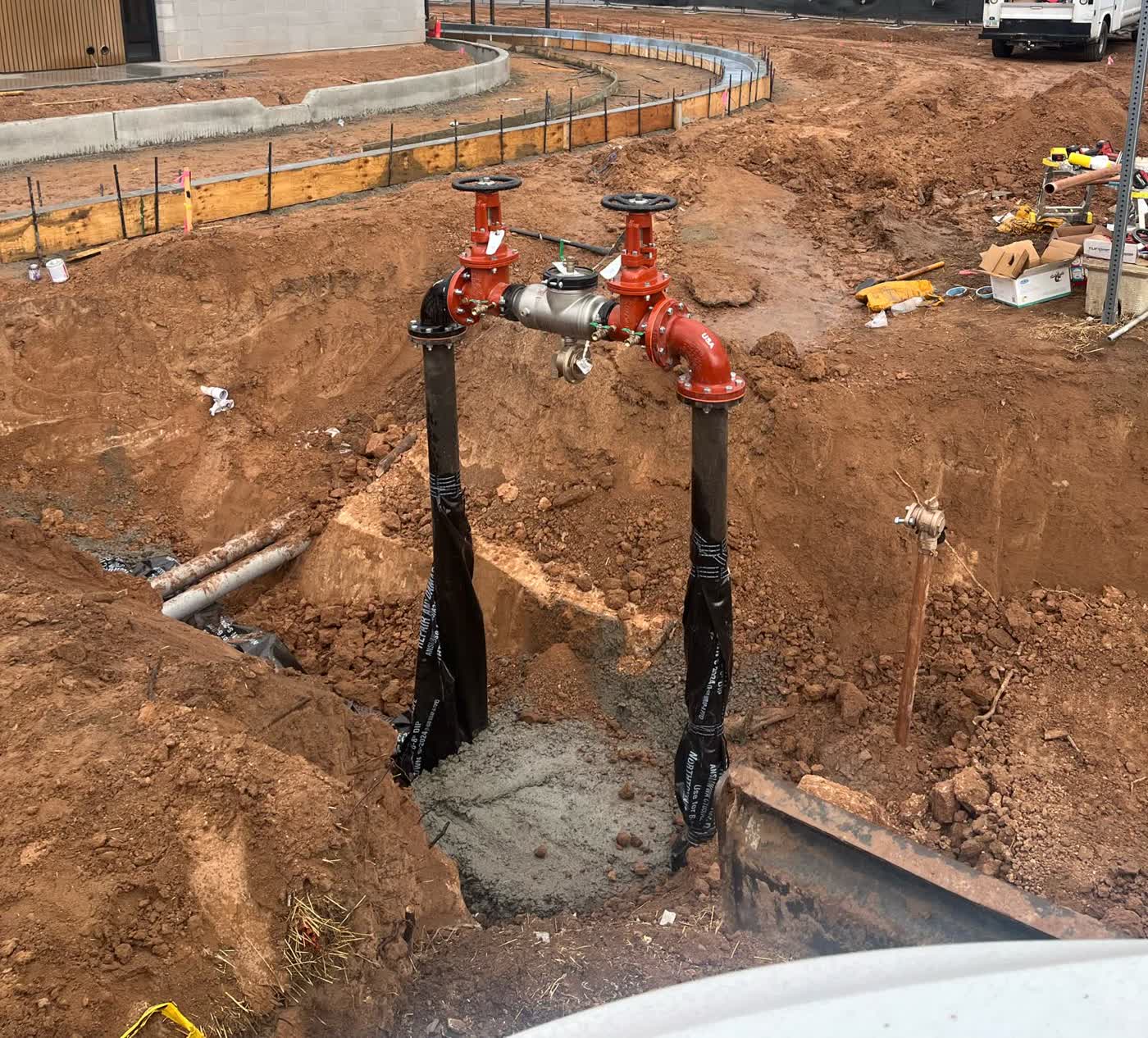 Red backflow preventer assembly installed in a utility trench