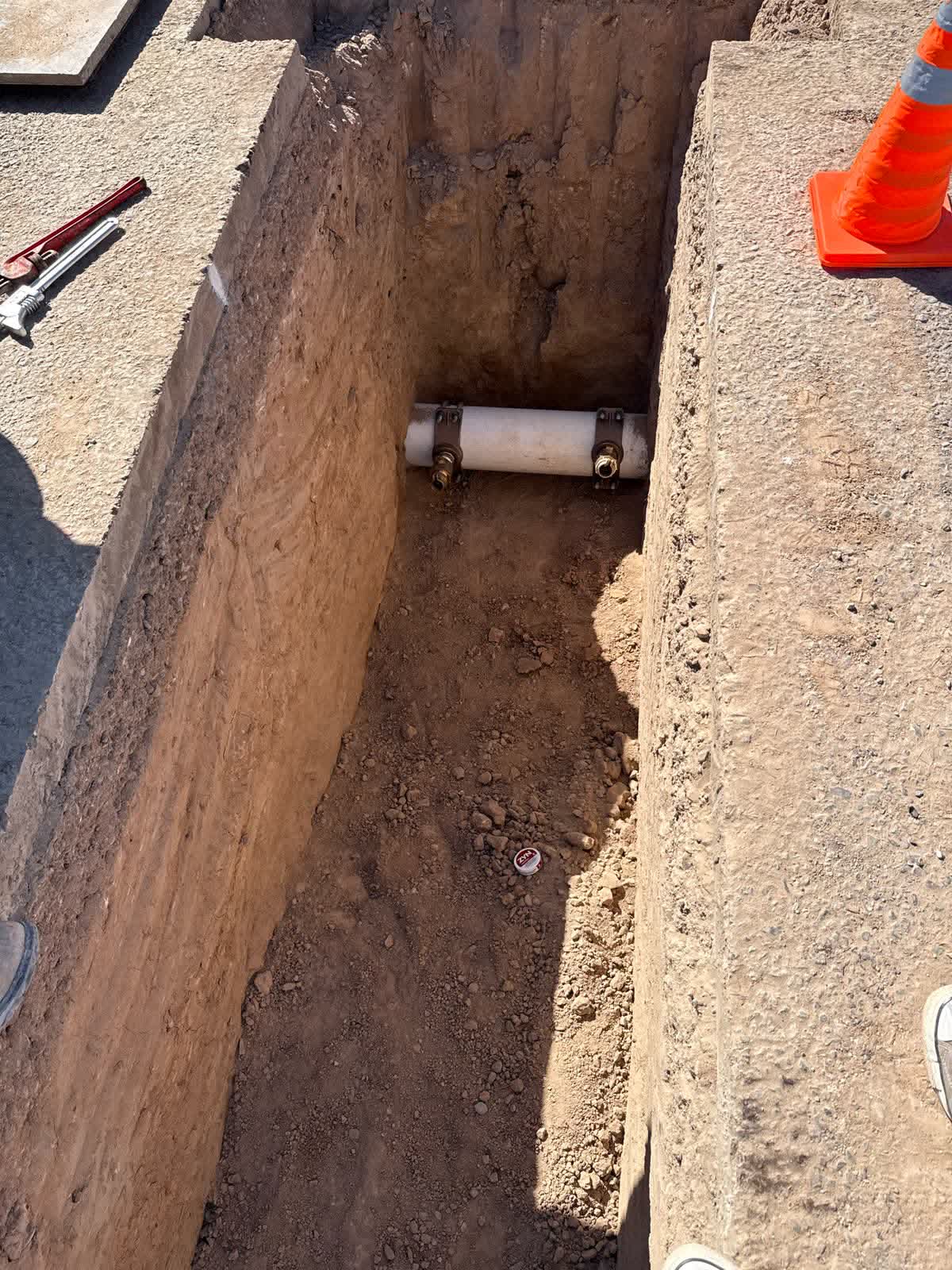 PVC saddle taps on a water service line with wrenches