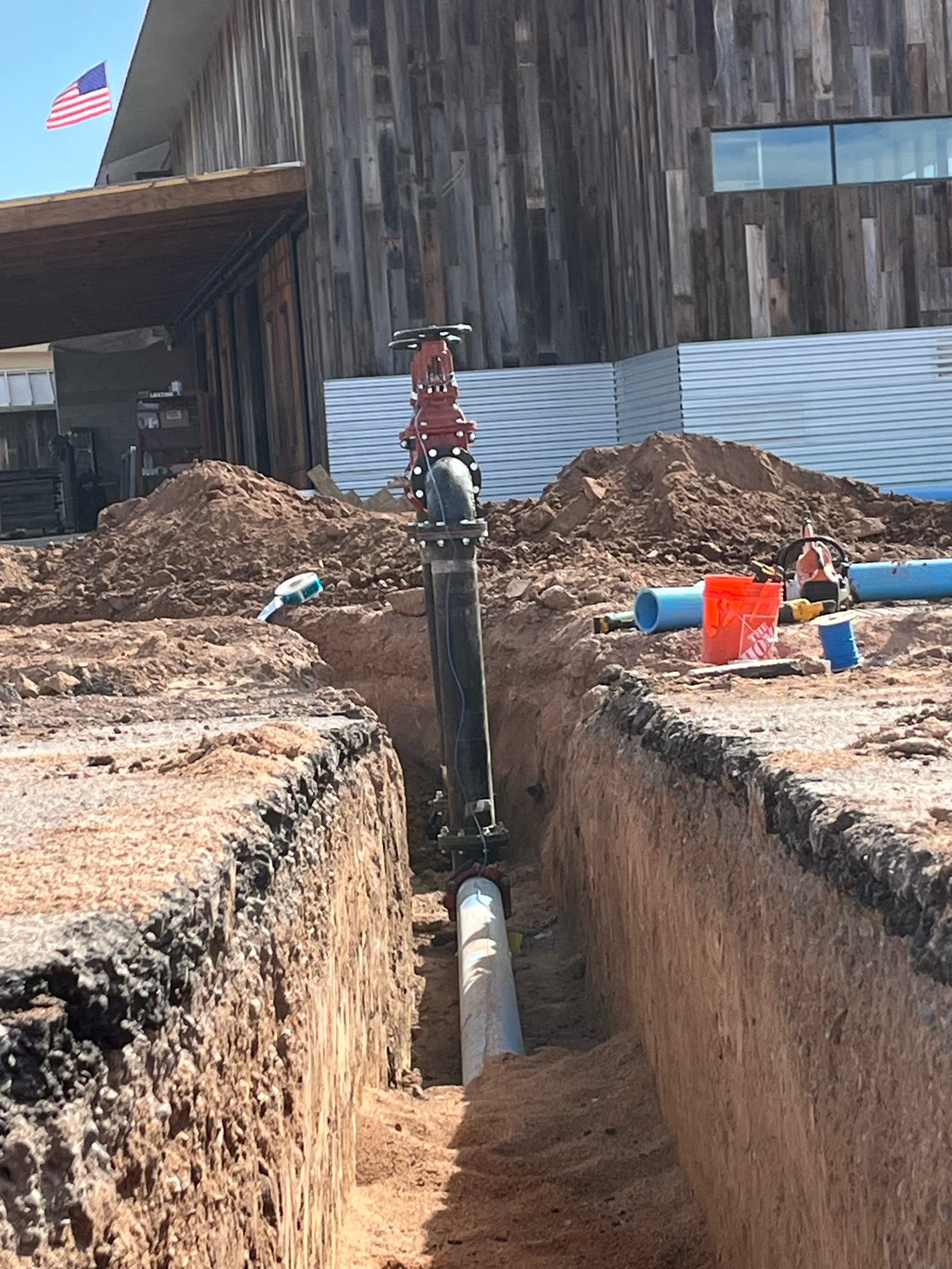 Water valve riser and pipe in an open utility trench